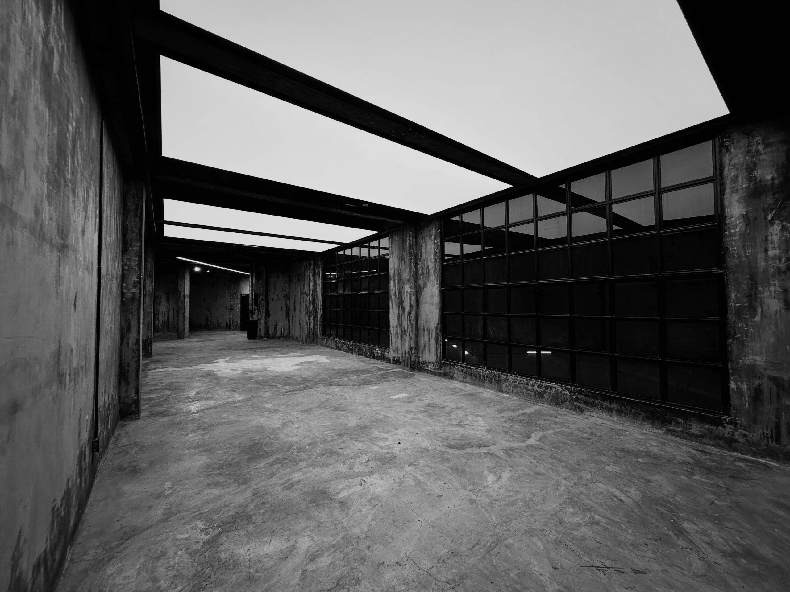 Creative studio rental Phra Khanong — raw concrete room with considered light at Begrüntes Haus, Phra Khanong