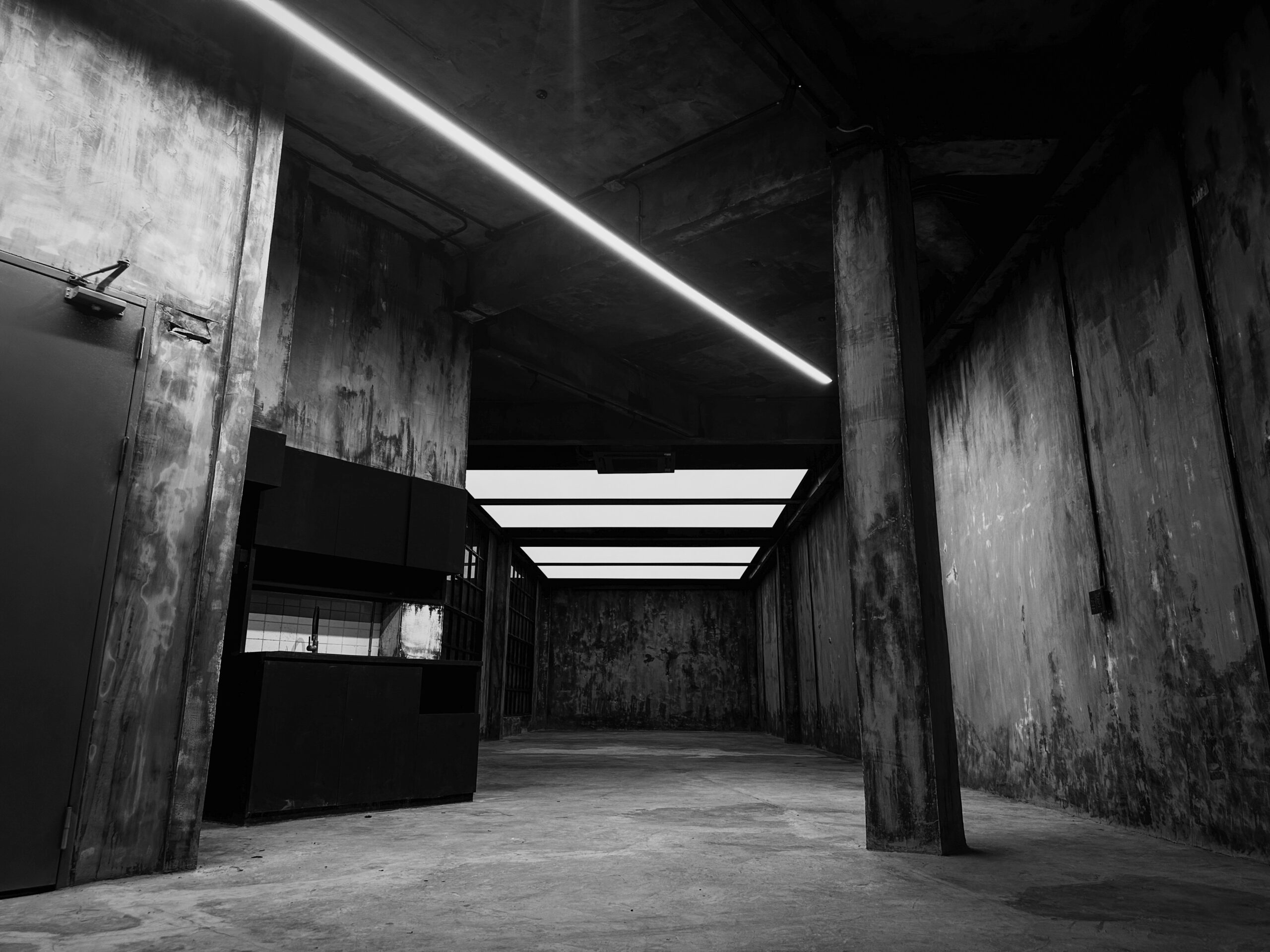 Gallery space rental Bangkok — raw concrete room with considered light at Begrüntes Haus, Phra Khanong