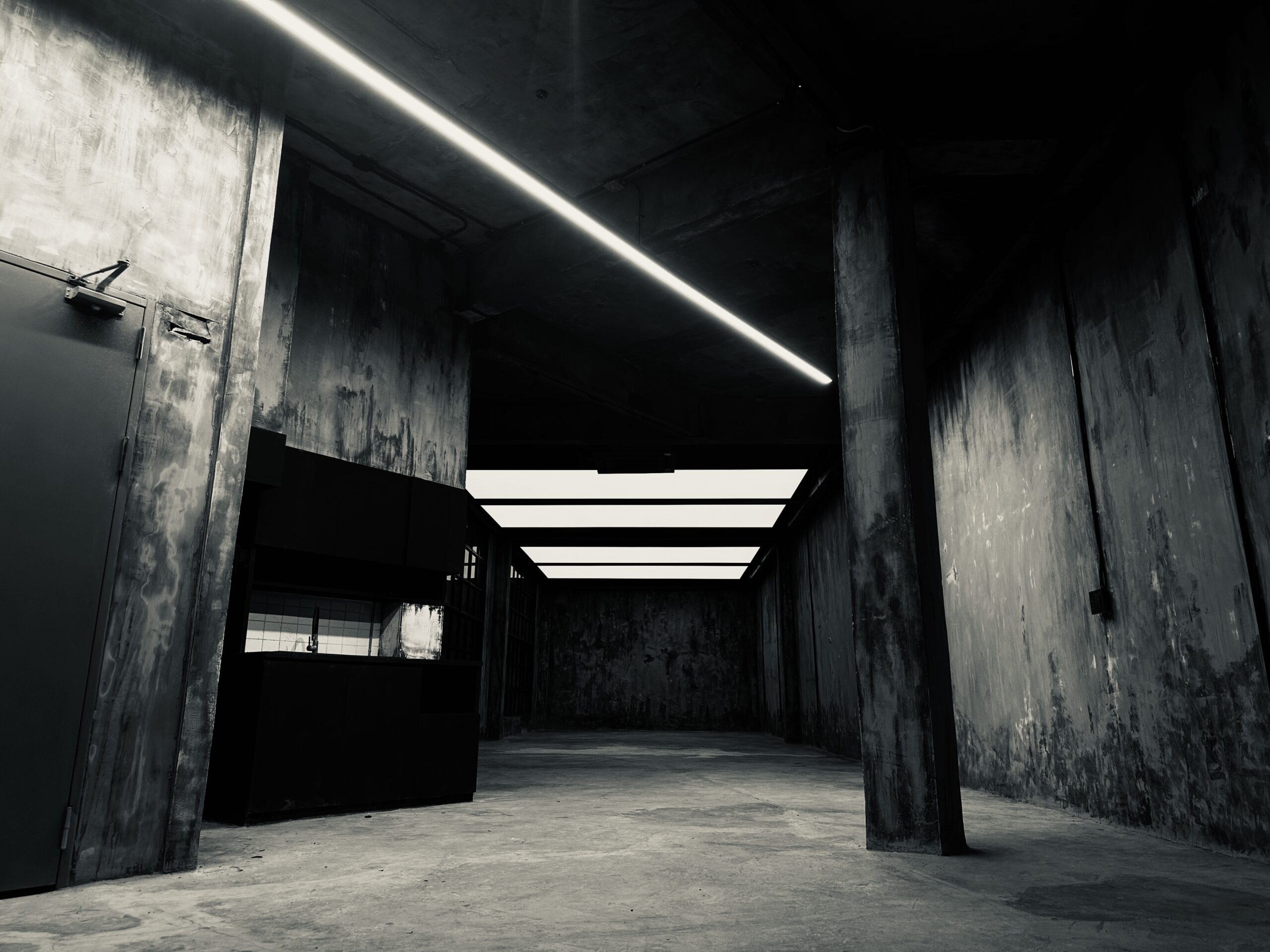 Creative studio rental Phra Khanong — raw concrete room with considered light at Begrüntes Haus, Phra Khanong